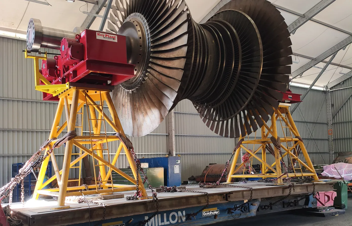 Rotor de una turbina de gas montado sobre caballetes amarillos en un taller, listo para su traslado